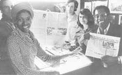 Peoples Temple staff members holding the first large format, newsprint issue of Peoples Forum in December 1976. Left to right: Tim Carter, Frances Johnson, Tim Clancey, Gloria Rodriguez (Carter), Jim Ingram. 